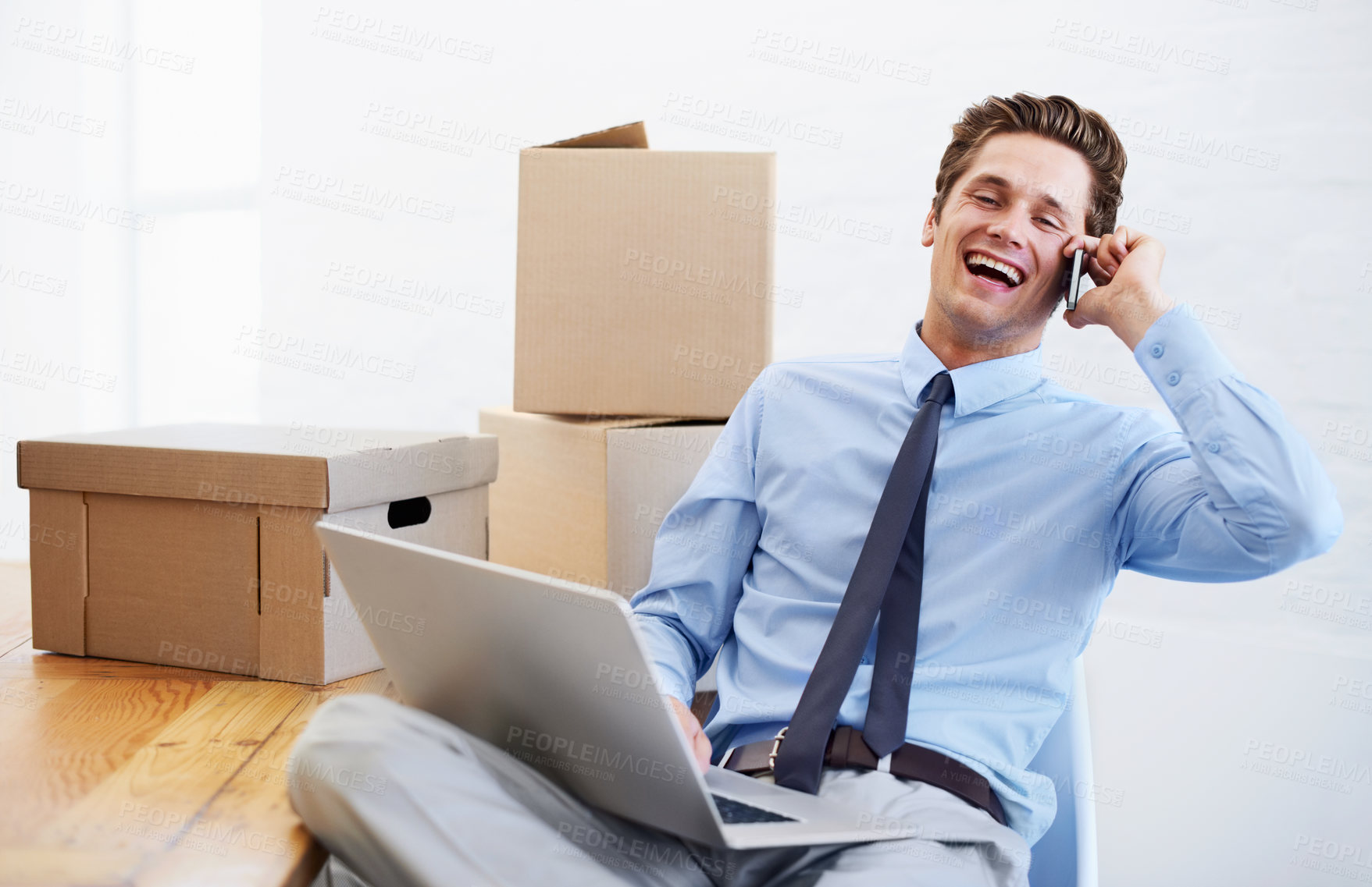 Buy stock photo An excited businessman on his cellphone after moving offices