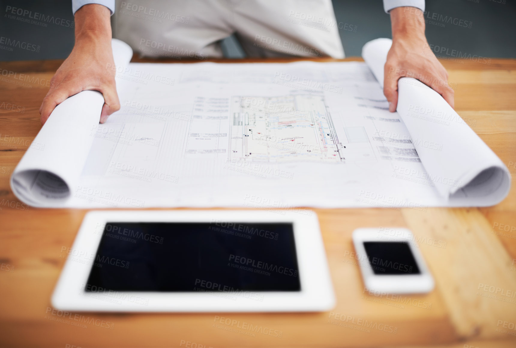 Buy stock photo Cropped image of an architect going over his blueprints