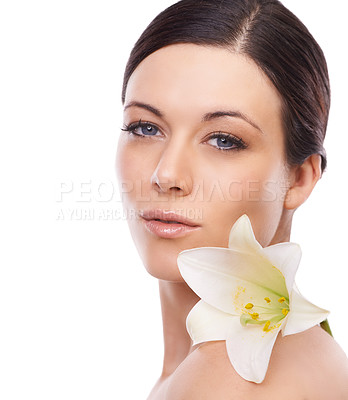 Buy stock photo A lovely young woman looking at the camera with a lilly resting on her shoulder
