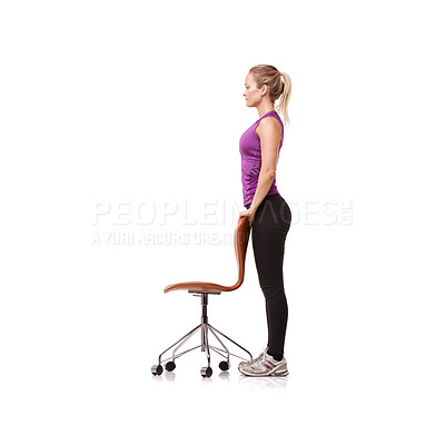 Buy stock photo A beautiful young woman wearing gym clothes and standing while using a chair for support against a white background