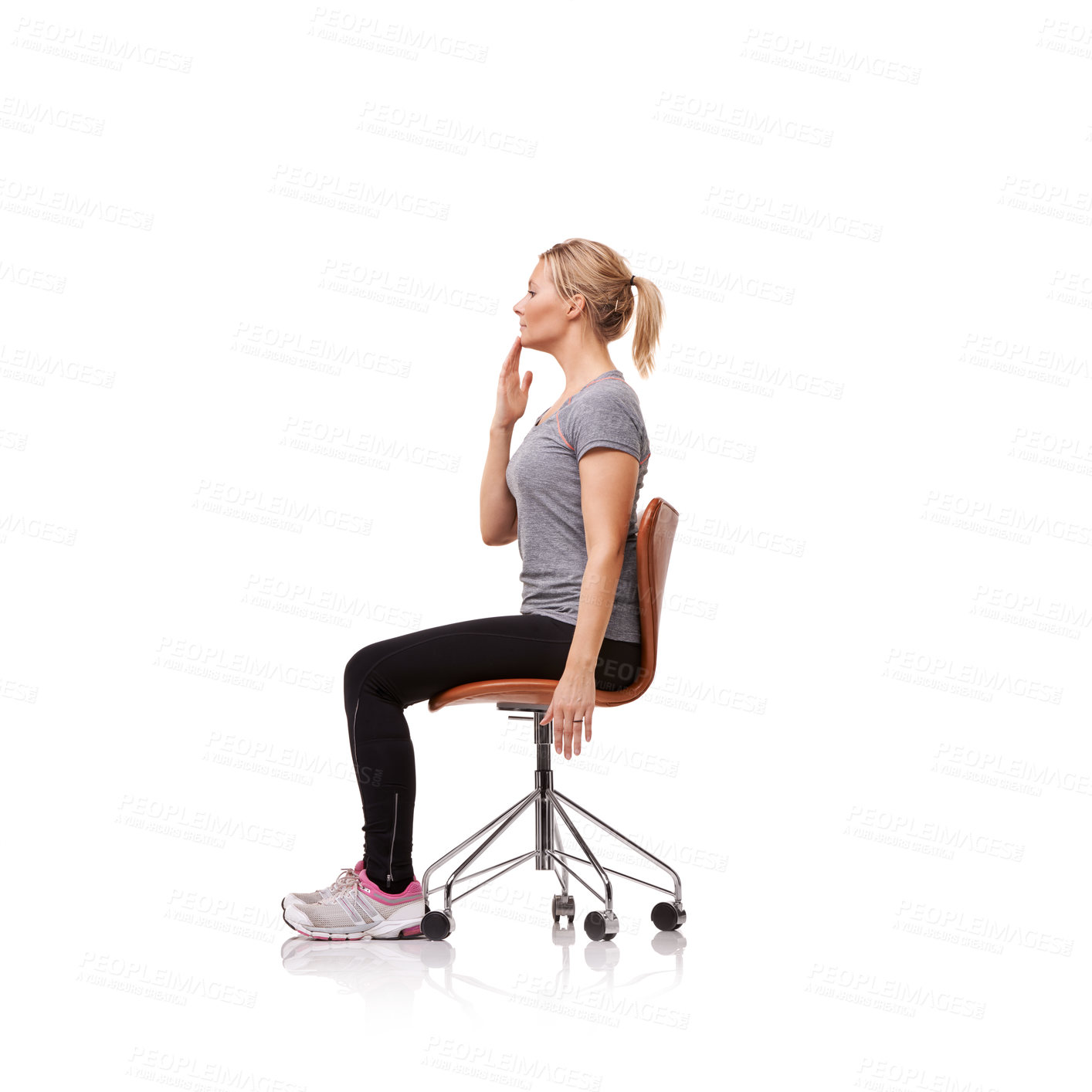 Buy stock photo Shot of a sporty woman doing stretches on a chair