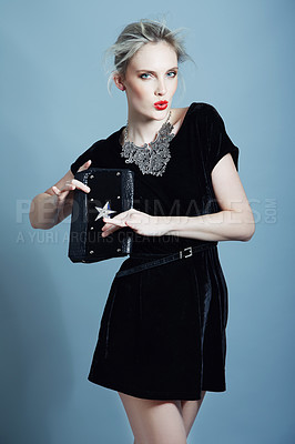 Buy stock photo A gorgeous young woman modeling an evening dress while holding a clutch bag