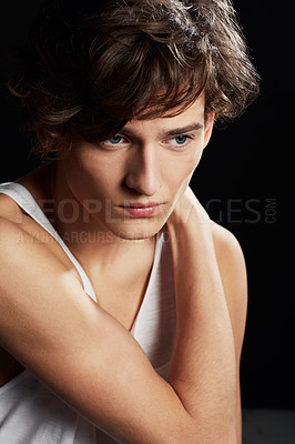 Buy stock photo Portrait of a thoughtful young man wearing a vest while posing against a black background