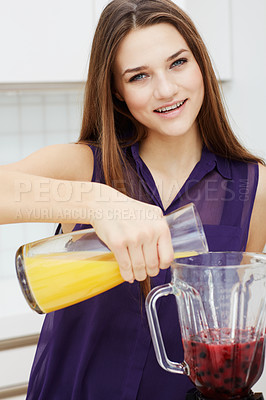 Buy stock photo Portrait of a beautiful young woman making a healthy shake with her blender