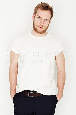 Buy stock photo Portrait of a young man standing against a wall with his hands in his pockets