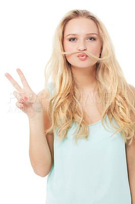 Buy stock photo A quirky young blonde showing you a peace sign with her hair over her mouth - isolated