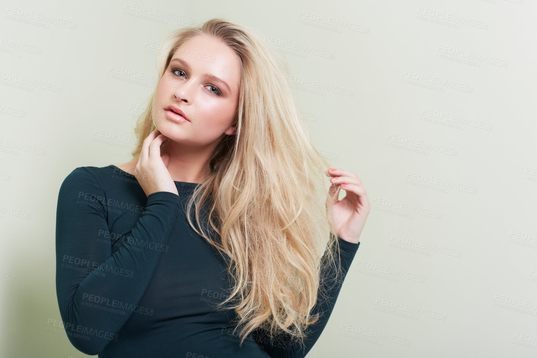 Buy stock photo A stunning young model pulling at her hair while posing alongside copyspace