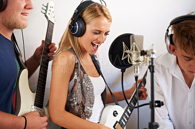 Buy stock photo Band, guitar and woman with microphone, headphones and music performance with talent. Recording studio, art and happy girl musician live streaming voice for record label, sound and audio broadcast.