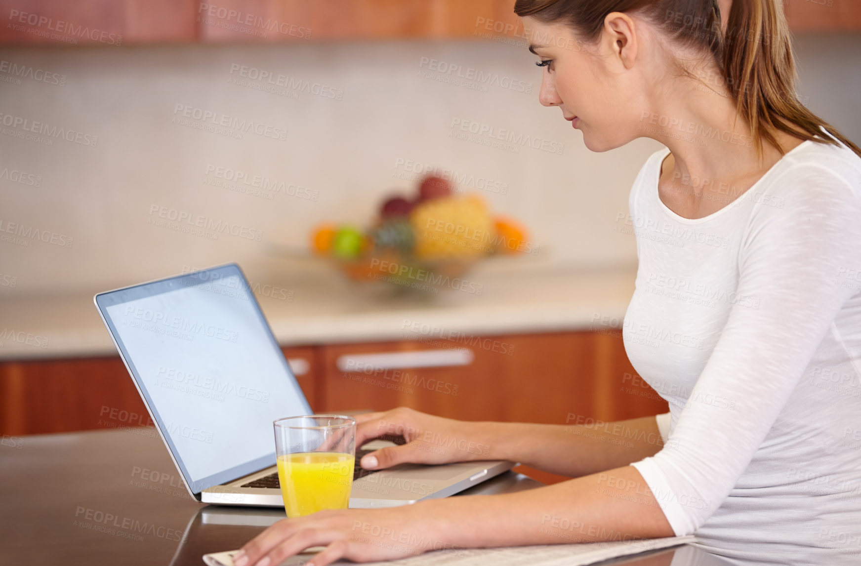 Buy stock photo Cropped shot of an attractive young woman using her laptop  while relaxing at home