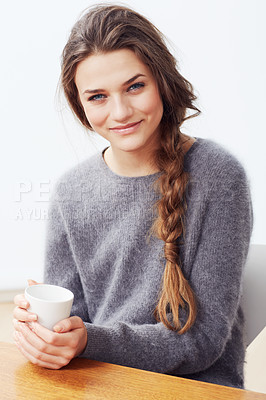 Buy stock photo Portrait of a young woman holding a coffee cup and smiling at the camera