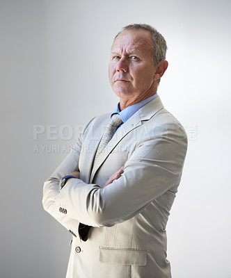 Buy stock photo A mature businessman crossing his arms sternly