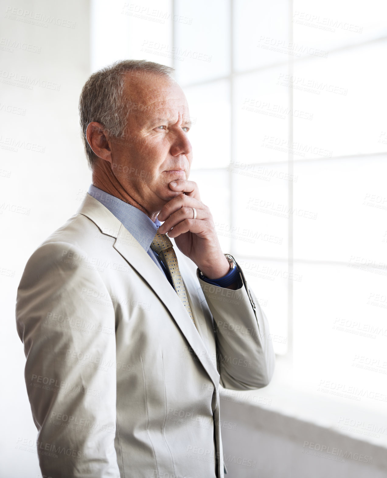 Buy stock photo A thoughtful businessman looking out of his office window