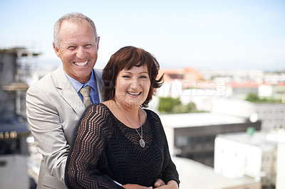 Buy stock photo An affectionate mature couple embracing against a scenic view of the city