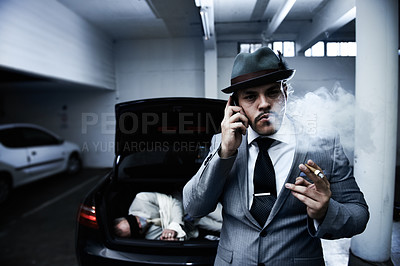 Buy stock photo An arrogant mobster smoking a cigar and informing his employer that the abduction was successful