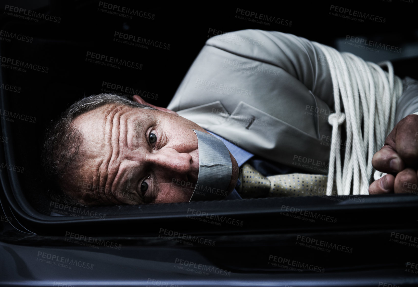 Buy stock photo Portrait of a frightened businessman lying bound and gagged in the trunk of a car