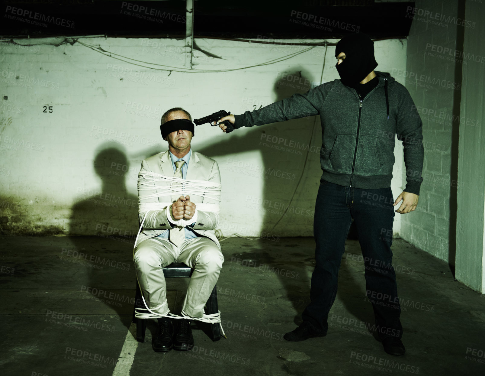 Buy stock photo Man, kidnap and gangster with gun for crime, ransom and negotiation in terror, abduction and danger at night. Criminal, scared person or hostage in fear for life, tied up and blindfolded in shooting