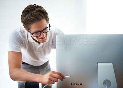 Buy stock photo A computer technician plugging a computer in