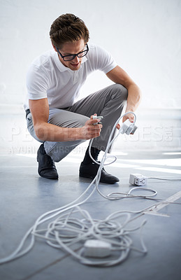 Buy stock photo A young man plugging in a plug