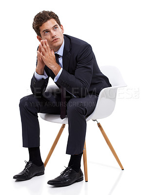 Buy stock photo A pensive young businessman sitting on a chair against a white background
