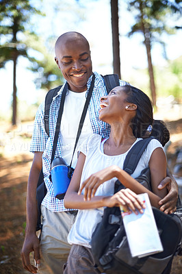 Buy stock photo Happy black couple, hiking and bonding in forest for outdoor adventure, travel or holiday together in nature. African man and woman smile in woods enjoying fresh air, trip or trekking for weekend