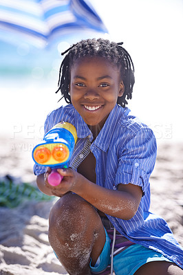 Buy stock photo Child, water gun and beach to play, portrait and happy with sand, fighting and swimwear for summer vacation. Nature, resting and enjoy for holiday, sun tan or seaside in outdoor, beautiful or ocean 
