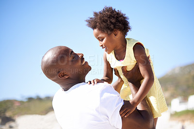 Buy stock photo Lifting, hug and father and daughter at a beach with love, trust or support in nature together. Black family, happy and dad with girl child at the ocean for travel, fun or summer, vacation to holiday