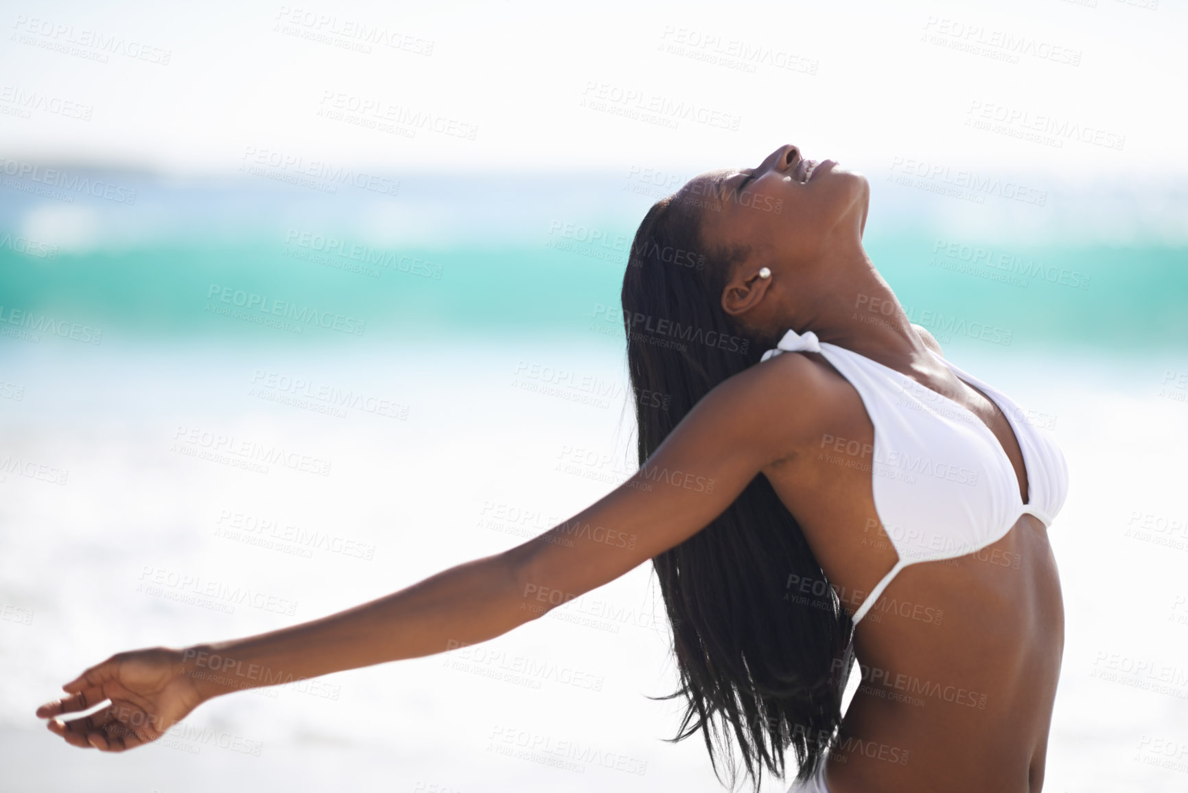 Buy stock photo An african-american woman with her arms outstretched and eyes closed at the beach