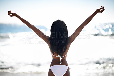 Buy stock photo Rear-view of an african american woman with her arms raised to the ocean