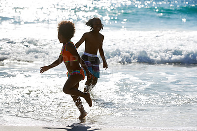 Buy stock photo African kids, beach and playing in water at sea, smile and having fun together on summer holiday. Children, ocean and siblings, brother or sister on vacation, travel and happy family running outdoor