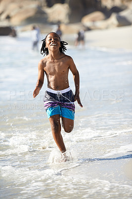 Buy stock photo Running, black boy and happiness on beach with energy for adventure, holiday or vacation in summer. African kid, face and smile outdoor in nature for break, experience or getaway by ocean or sea 