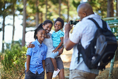 Buy stock photo Smile, photograph and a black family hiking in the forest together for travel, tourism or adventure. Love, photography or memory with a man, woman and children in the woods or wilderness for freedom