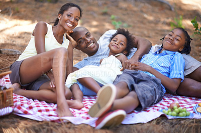 Buy stock photo Portrait, relax and black family with forest picnic, hug or bonding in nature together. Love, food and children lying with parents in park for fruit, nutrition or healthy snacks for vacation in woods