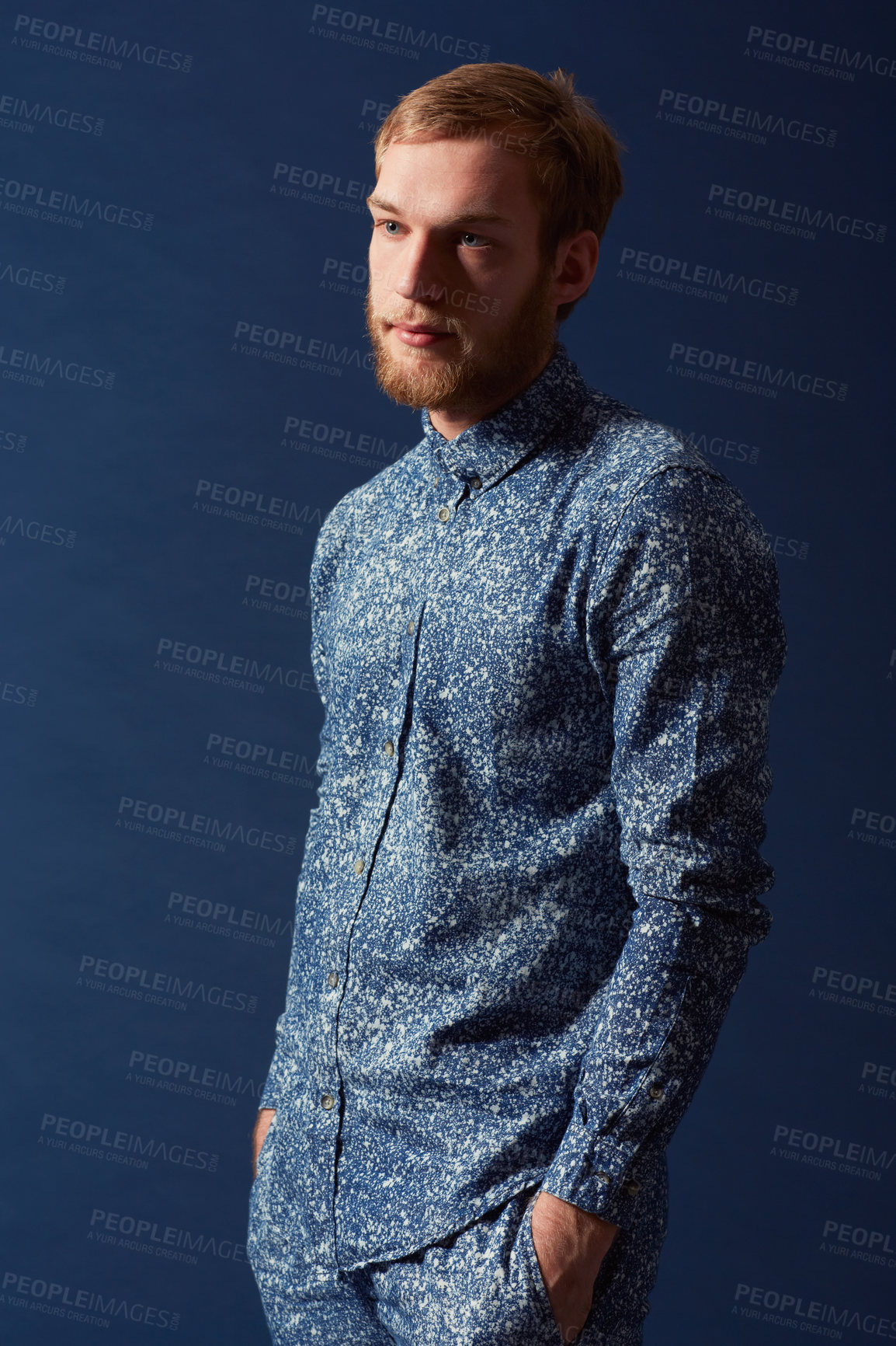 Buy stock photo Man, fashion and chic clothes in studio with unique style, denim and trendy on blue background. Irish odel with hipster beard, red hair with serious face and stylish, fashionable shirt and jeans