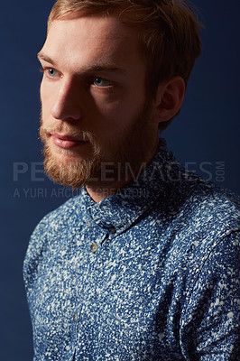Buy stock photo Man, fashion and serious face in studio with unique style, denim and trendy on blue background. Irish model with hipster beard, red hair with casual clothes and stylish, fashionable shirt in headshot