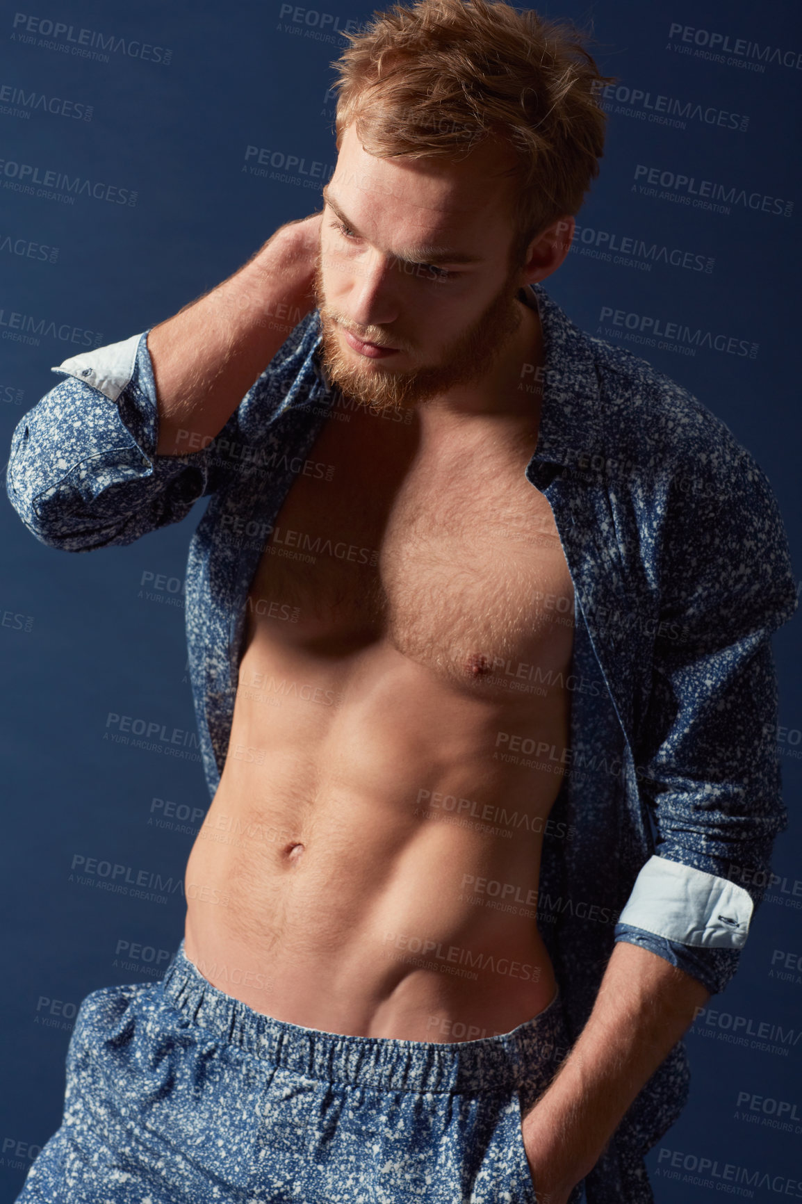 Buy stock photo Fashion, body and muscle with a man in studio on a blue background wearing an open unbuttoned shirt. Fitness, chest and abs with a handsome young male model posing on a color wall for masculine style