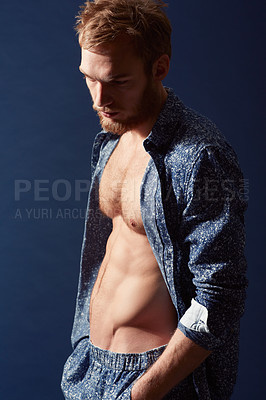 Buy stock photo Fashion, thinking or model with abs in studio on a blue background wearing an open unbuttoned shirt. Ginger man, body or handsome male person posing on color wall for masculine style with six pack