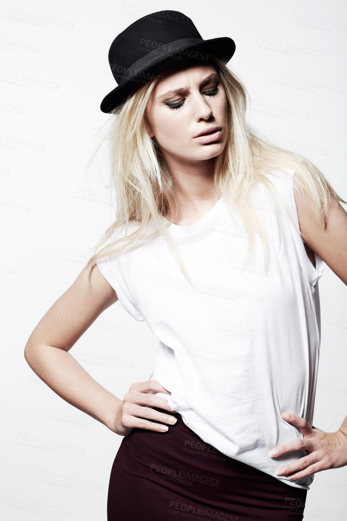 Buy stock photo A trendy young blonde model wearing a bowler hat while isolated on white