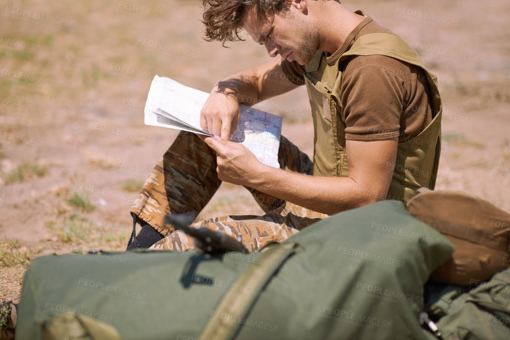 Buy stock photo Man with map on battlefield, planning battle location or tactical operation goals for mission in war. Soldier is outdoor at military base camp, check strategy paperwork with army target and attack