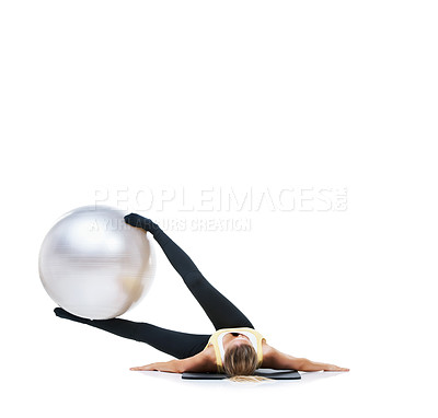 Buy stock photo Shot of a female holding an exercise ball up with her legs