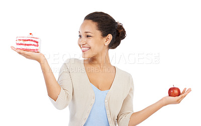 Buy stock photo Young woman smiling while trying to decide between a piece of cake and an apple - isolated on white
