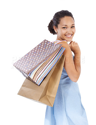 Buy stock photo Young woman smiling while holding her purchases after a shopping day - isolated