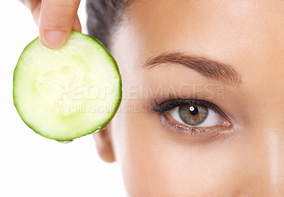 Buy stock photo Woman, face and cucumber by eyes in beauty, facial or spa treatment on a white studio background. Closeup of female person and natural organic vegetable for anti aging benefits in health and wellness