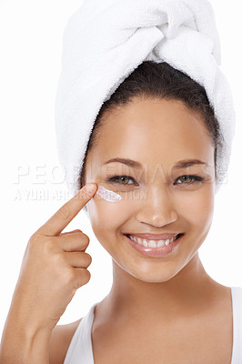 Buy stock photo Happy woman, face and beauty cream, skincare and cosmetics on a white background. Portrait of an African model or person smile and apply moisturizer, lotion or eye product for dermatology in studio