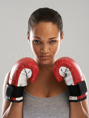 Buy stock photo Serious woman, portrait and professional boxer ready for fight or competition against a gray studio background. Female person with boxing gloves for self defense, power or challenge in sports fitness