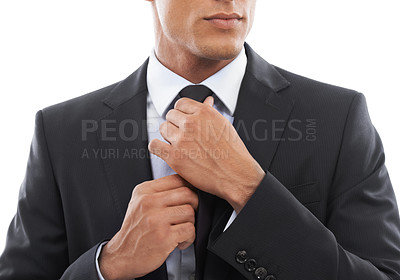 Buy stock photo Cropped image of a businessman fixing his tie against a white background