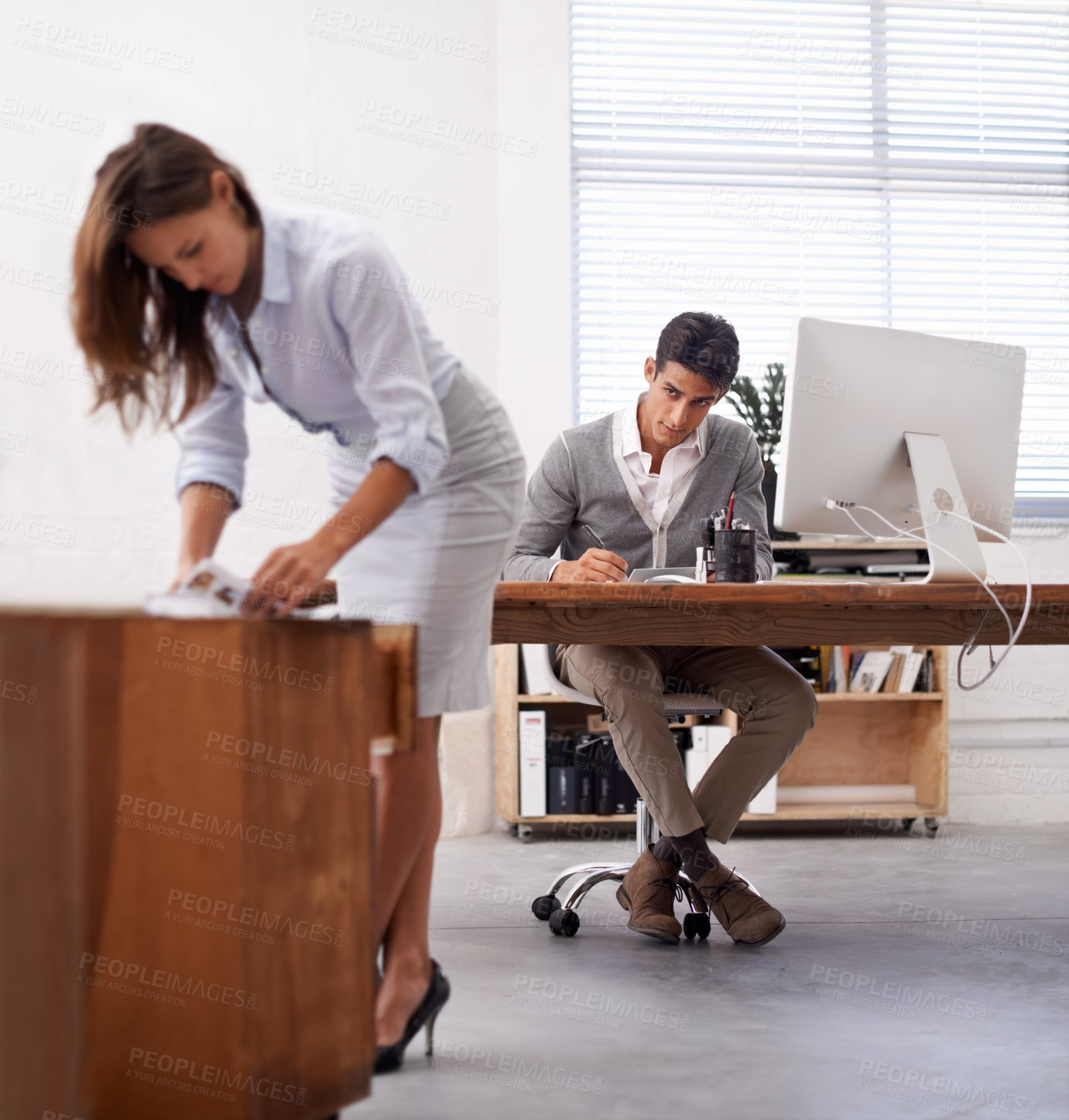 Buy stock photo Affair, infidelity or sexual harassment with business man by desk at work, looking at bum of colleague. Computer, receptionist or temptation and young employee in office with sexy woman coworker