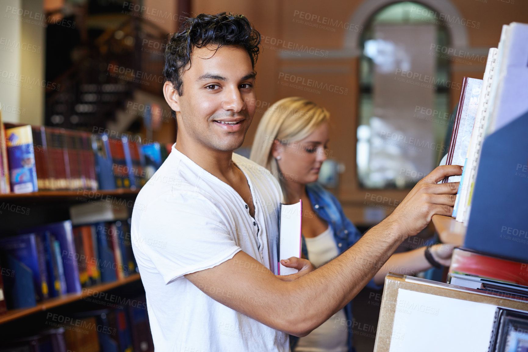 Buy stock photo Portrait, book or student in a library to search at university, college or school campus for education. Bookshelf, learning or happy man with scholarship studying knowledge, research and information