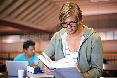 Buy stock photo Reading book, knowledge or student in library at university, college or school campus for education. Glasses, nerd or male person serious about scholarship studying, research or learning information 