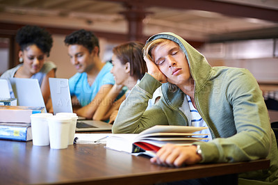 Buy stock photo A young student looking bored while in his classmates study int the background