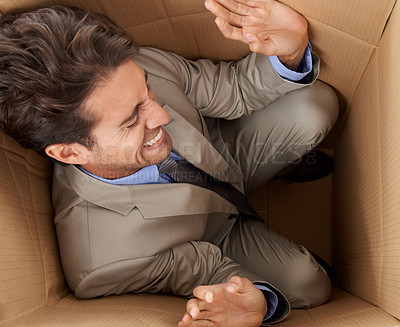 Buy stock photo Concept shot of a young businessman trapped in a cardboard box